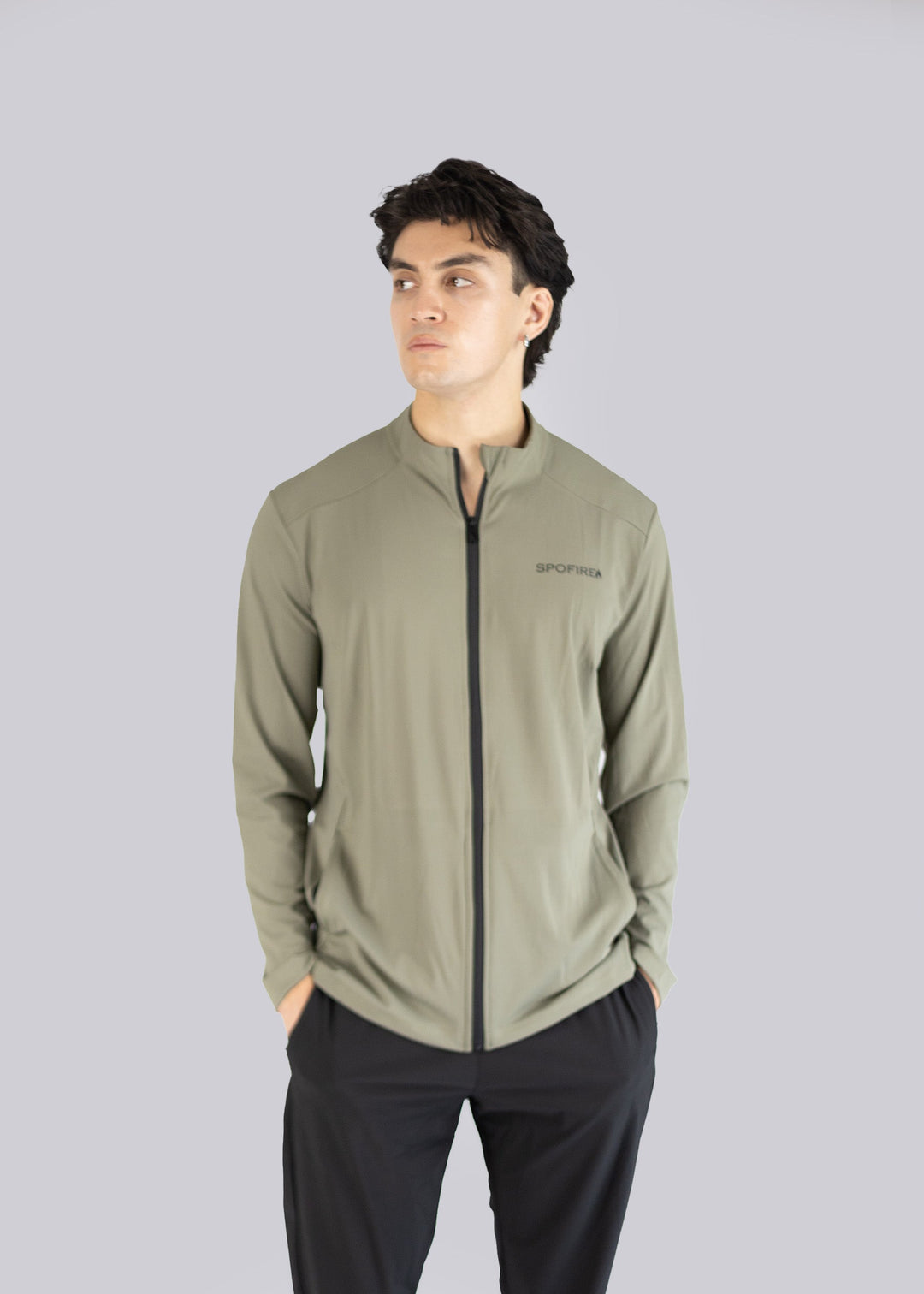 Man wearing an olive jacket with a Spofire logo on a gray background