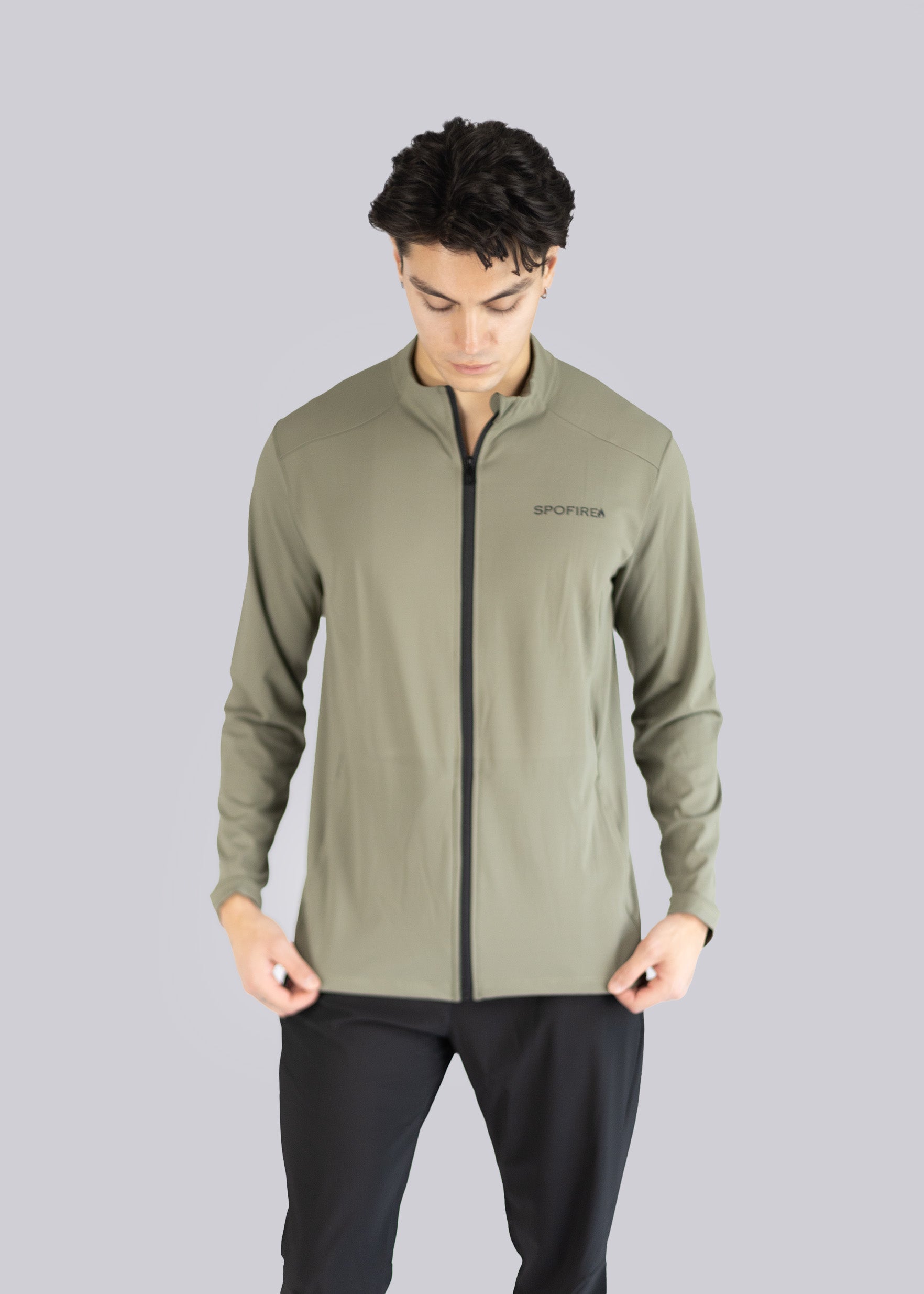 Man wearing a green jacket with a Spofire logo on a gray background