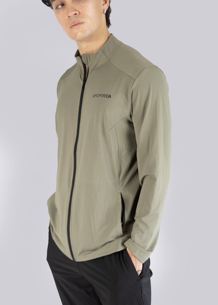 A man wearing an olive  jacket with a Spofire logo on a gray background