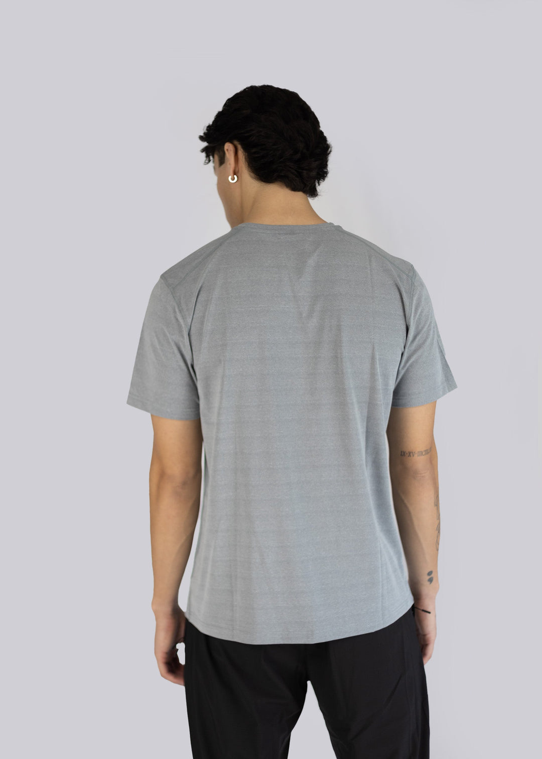 A man wearing a gray t-shirt on a plain background photo