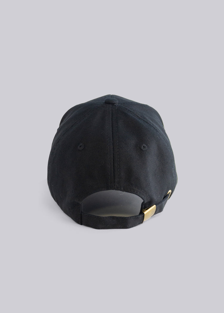 Black cap with a gold emblem on a light gray background
