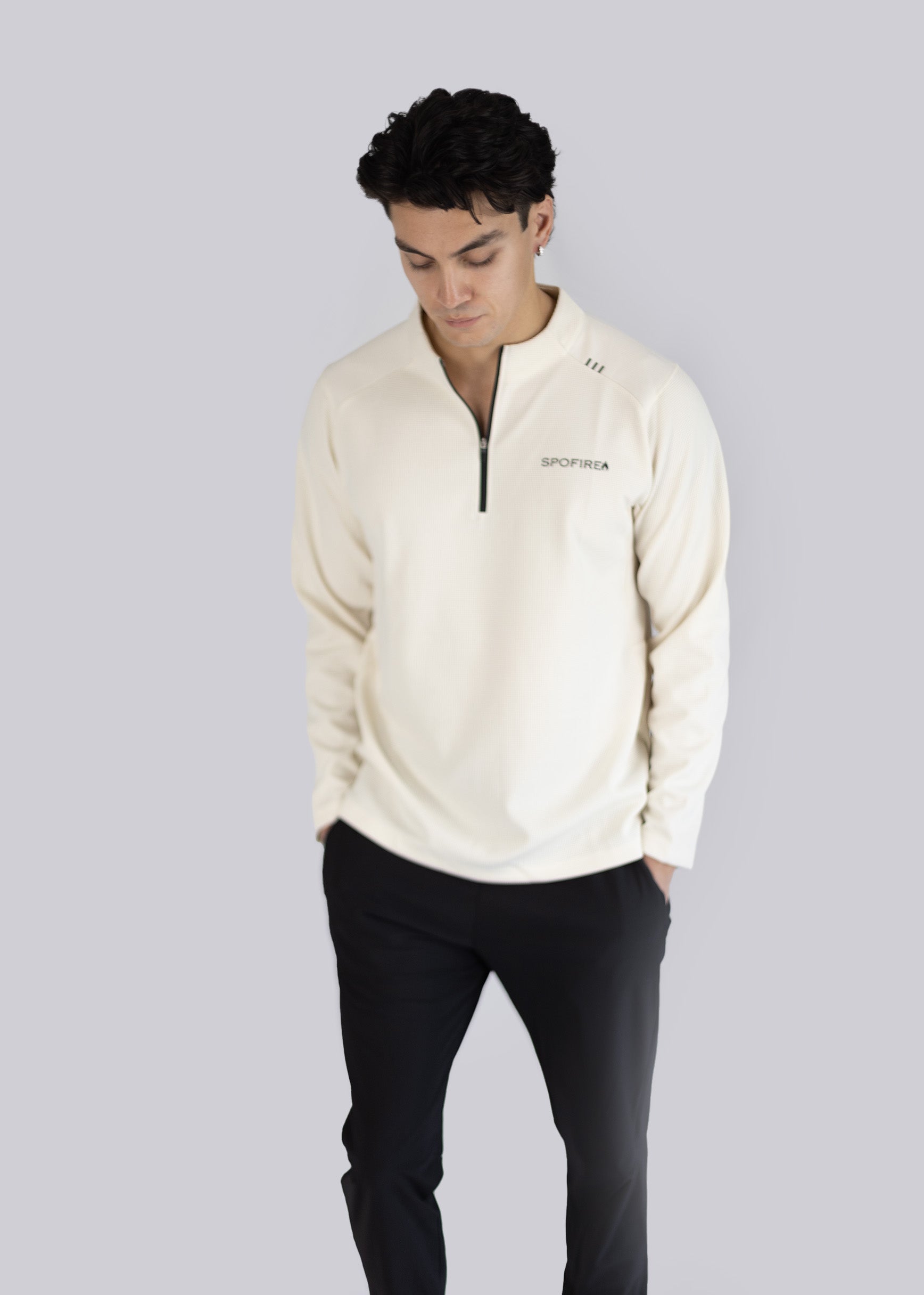 A man wearing a white sweater with the Spofire logo on a light gray background