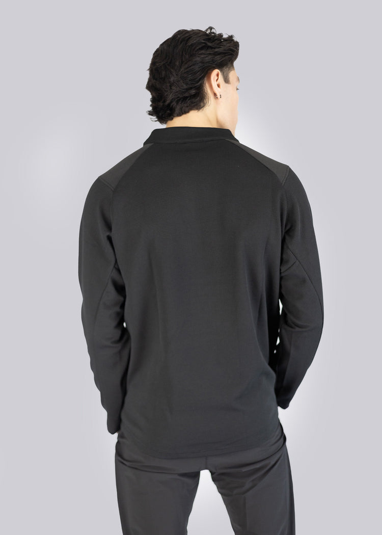 Person wearing a black long-sleeve athletic Sweater on a gray background